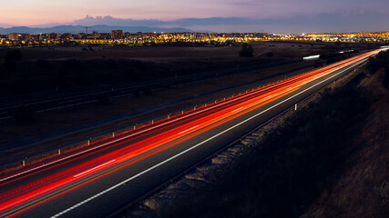 Fototapeta na wymiar Car light trails on a straight road at dusk in the city