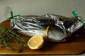 Cooked for baking marinated mackerel with lemon and rosemary, sealed in a celophane sleeve