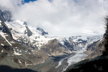 spectacular view of clouds over the snow covered mountains at the summit of Grossglockner in the austrian alps with the Pasterze 