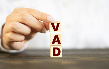 Businessman made word VAD with wood building blocks.