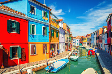 Obraz na płótnie Canvas Colorful houses of Burano island. Multicolored buildings on fondamenta embankment of narrow water canal with fishing boats in sunny day, Venice Province, Veneto Region, Northern Italy. Burano postcard