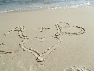 heart and letters on sand