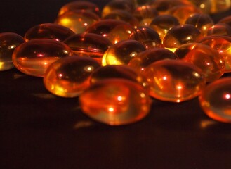 Trans-lucid cod liver oil pills under colourful light