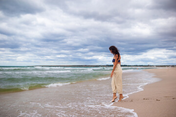 Young woman on the beach in the storm