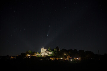 Naklejka premium La comète Neowise c/2020 s'affiche haute, majestueuse, dans ce ciel limpide juste au-dessus de château de Rue dans le canton de Fribourg en Suisse romande.
