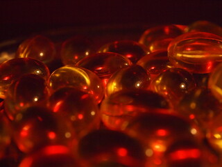 Trans-lucid cod liver oil pills under colourful light