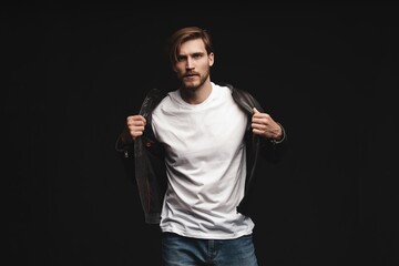 Naklejka premium Fashion man, Handsome serious beauty male model portrait wear leather jacket, young guy over black background