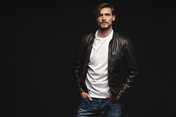 Fototapeta premium Fashion man, Handsome serious beauty male model portrait wear leather jacket, young guy over black background