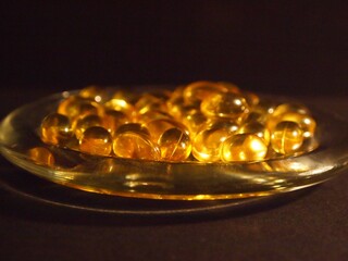 Trans-lucid cod liver oil pills under colourful light