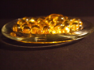 Trans-lucid cod liver oil pills under colourful light
