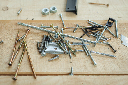 Drills and screws made from steel, screw nut On a wooden background table, workshop background