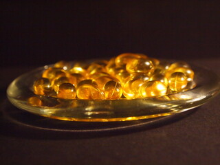 Trans-lucid cod liver oil pills under colourful light