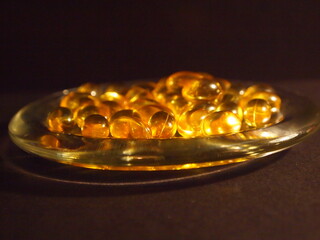 Trans-lucid cod liver oil pills under colourful light