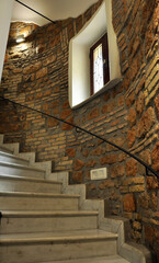 Ancient marble spiral staircase with brick walls, in an Italian house. 