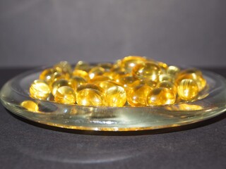 Trans-lucid cod liver oil pills under colourful light
