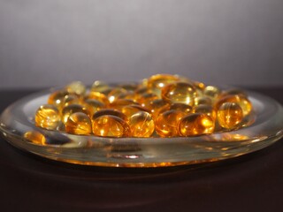 Trans-lucid cod liver oil pills under colourful light