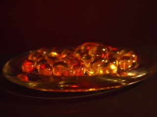 Trans-lucid cod liver oil pills under colourful light