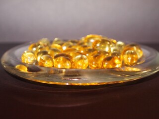 Trans-lucid cod liver oil pills under colourful light
