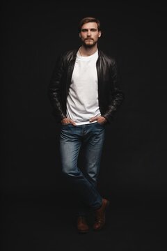 Fashion man, Handsome serious beauty male model portrait wear leather jacket, young guy over black background