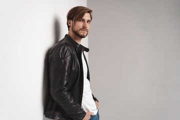 Obraz premium Fashion man, Handsome serious beauty male model portrait wear leather jacket, young guy over white background