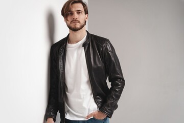 Fototapeta premium Fashion man, Handsome serious beauty male model portrait wear leather jacket, young guy over white background