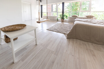 Fototapeta premium Luxury bedroom design in a rustic cottage in a minimalist style. white walls, panoramic windows, wooden elements of decoration on the ceiling, rope swings in the middle of a spacious room