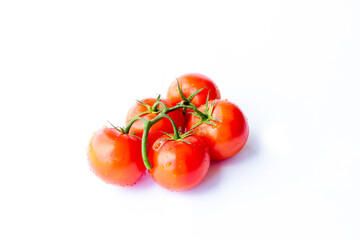 On a white background. No isolation. Red tomato on a green branch. There is a shadow.