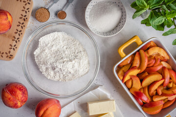 White table with ingredients for peach cobbler pie