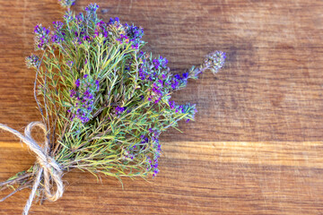 A bunch of fresh thyme lies on an old wooden background. Top view, flat lay. Fresh herb. Selective focus, copy space