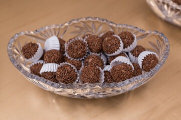 Montes de brigadeiros dentro de vasilha de vidro em buffet.
