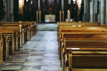 Passage d'une église avec des bancs en bois vide et une lumière latérale