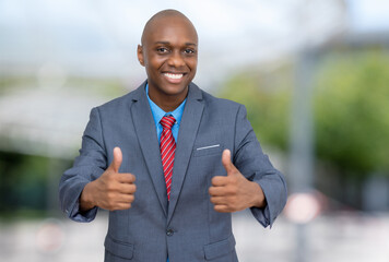 Successful african american businessman showing thumbs up outdoors in the city