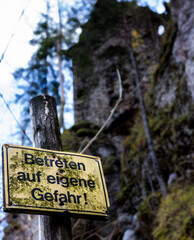beware of trespassing warning sign in front of a castle ruin in the austian alps