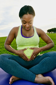 Pregnant woman holding her stomach in park