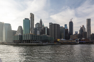 Naklejka premium miasto nad wodą latem na ładnym zachodzie słońca z bardzo wysokimi budynkami