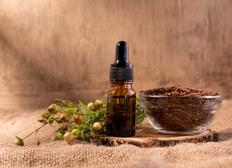 Flaxseed oil cosmetic bottle. Composition with dispenser bottle, flax seeds and plants.