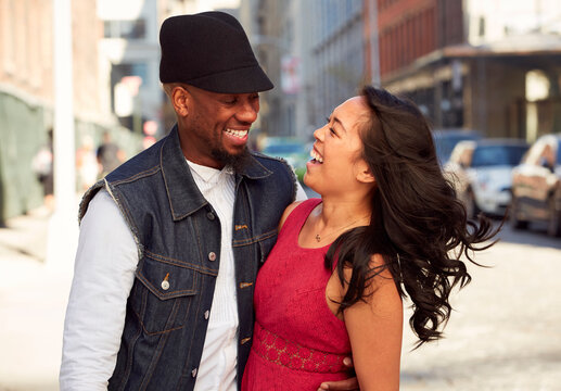 Couple laughing on city sidewalk