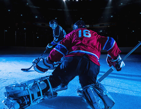 Hockey goalie in defensive position against forward