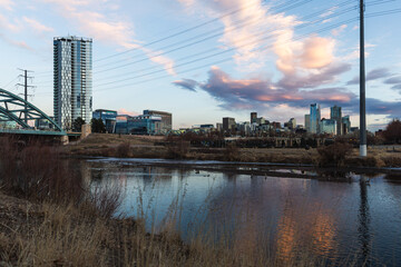 late view of a city after sunset with water in the foreground on a sunset