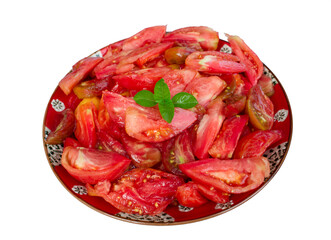 Slices of fresh juicy beef heart tomatoes with basil in a red plate with white background
