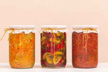 Homemade vegetable pickles on beige background.
