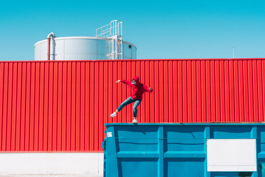 Young man balancing on edge of cargo container