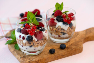 Granola parfait with yogurt and raspberries, blueberries and red currants. Ripe, bright, juicy berries. Summer snack.