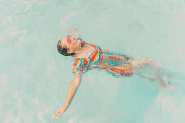 Dressed woman floating on water in swimming pool