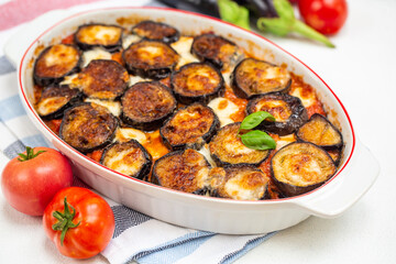 Homemade Parmigiana - typical Italian summer food: baked eggplants, moth tomato sauce and mozzarella and parmesan cheese.