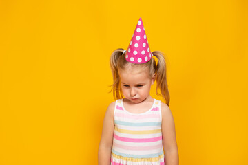 Unhappy blonde caucasian girl with sad or boring face on yellow studio background. Bad birthday...