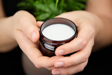 Organic shea butter in hands, natural moisturizing cosmetics, skin and hair care product.