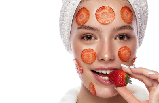 Beautiful tender young girl in white towel with clean fresh skin posing in front of the camera with a mask of Strawberry on face. Beauty face. Skin care.