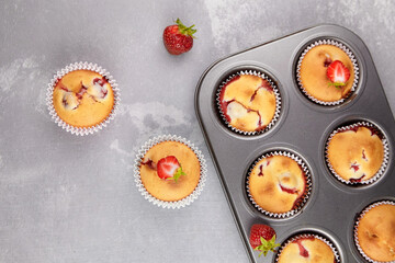 Summer dessert - strawberry muffins with fresh berries on grey concrete background
