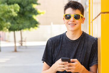 Fototapeta na wymiar young male teenager on the street with mobile phone